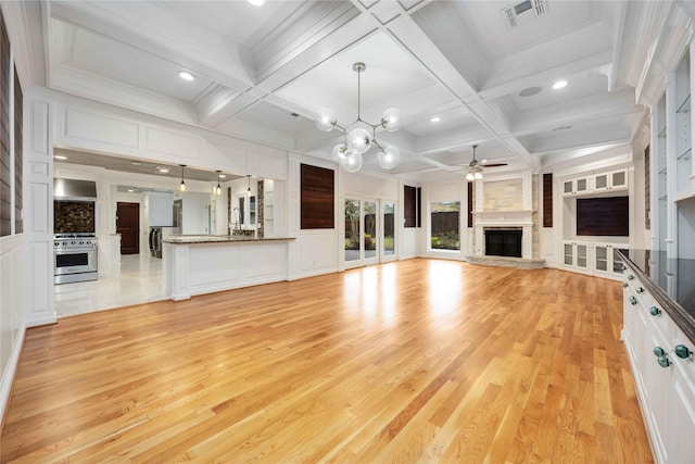 4031 Fernwood Dr, Houston, TX 77021 - unfurnished living room featuring a large fireplace, light wood-style floors, a ceiling fan, a decorative wall, and recessed lighting