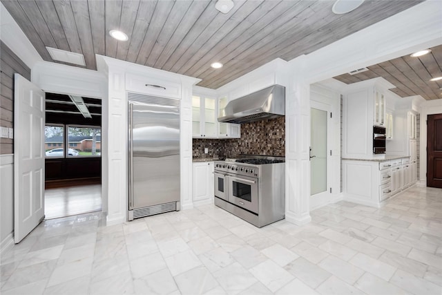 4031 Fernwood Dr, Houston, TX 77021 - kitchen featuring premium appliances, wall chimney exhaust hood, wooden ceiling, white cabinetry, and glass insert cabinets