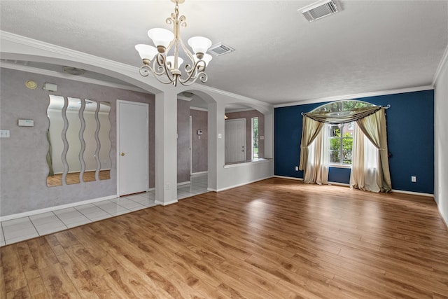 16418 Great Frst, Humble, TX 77346 - empty room with arched walkways, wood finished floors, ornamental molding, a chandelier, and a textured ceiling