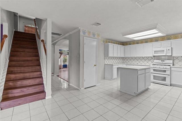 16418 Great Frst, Humble, TX 77346 - kitchen featuring white appliances, arched walkways, light countertops, tasteful backsplash, and white cabinetry