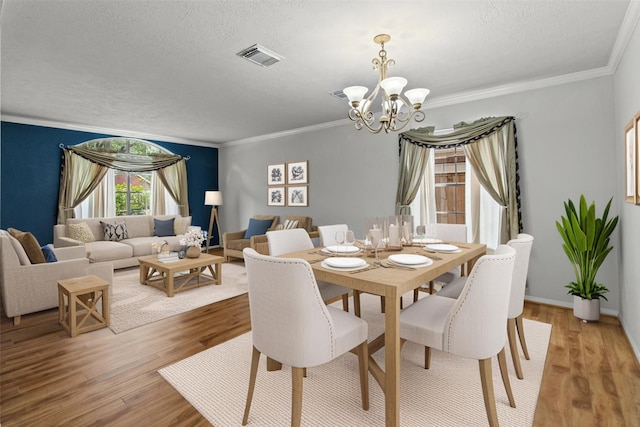 16418 Great Frst, Humble, TX 77346 - dining room with a chandelier, light wood finished floors, a textured ceiling, and crown molding