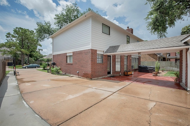 939 Mulberry Ridge Way, Houston, TX 77062 - rear view of house with brick siding, a hot tub, a patio, and a chimney