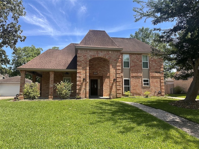 5306 Manor Glen Dr, Kingwood, TX 77345 - view of front facade with brick siding, a front yard, a shingled roof, and a garage
