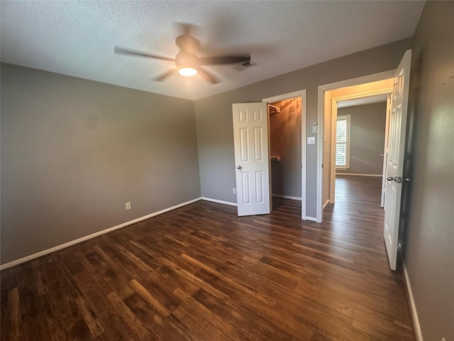 5306 Manor Glen Dr, Kingwood, TX 77345 - unfurnished bedroom featuring dark wood-type flooring, baseboards, a textured ceiling, and ceiling fan