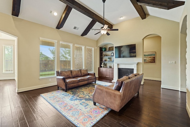 2014 Karankawa Trl, Katy, TX 77493 - living room with a glass covered fireplace, dark wood-type flooring, ceiling fan, baseboards, and arched walkways
