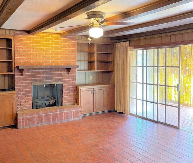 409 W Collier St, Jasper, TX 75951 - unfurnished living room with beam ceiling, a ceiling fan, tile patterned flooring, built in shelves, and a brick fireplace