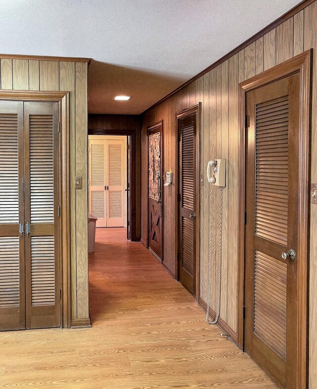 409 W Collier St, Jasper, TX 75951 - hall with a textured ceiling, light wood-style floors, ornamental molding, and wood walls