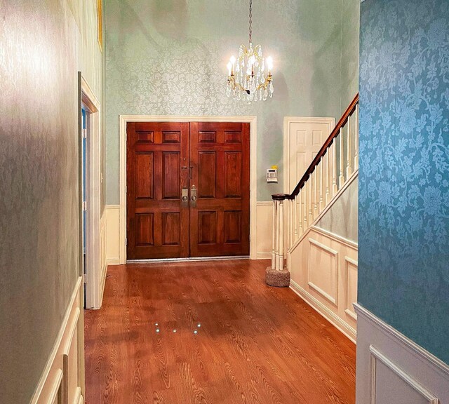 409 W Collier St, Jasper, TX 75951 - entrance foyer with wainscoting, a chandelier, stairs, wood finished floors, and a decorative wall