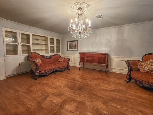 409 W Collier St, Jasper, TX 75951 - living area with a chandelier, crown molding, wainscoting, wood finished floors, and a decorative wall