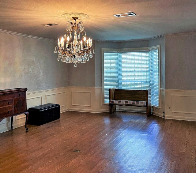 409 W Collier St, Jasper, TX 75951 - dining space with a chandelier, crown molding, dark wood-style flooring, a wainscoted wall, and a decorative wall