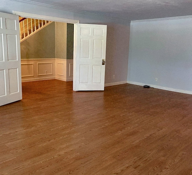 409 W Collier St, Jasper, TX 75951 - empty room with crown molding, wood finished floors, a decorative wall, a wainscoted wall, and stairway