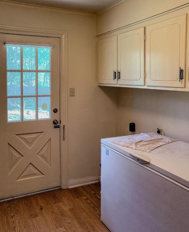 409 W Collier St, Jasper, TX 75951 - washroom featuring cabinet space, wood finished floors, baseboards, crown molding, and washer / clothes dryer