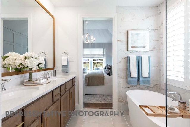 2334 Vargas St, Magnolia, TX 77316 - ensuite bathroom featuring healthy amount of natural light, a freestanding tub, double vanity, and a chandelier
