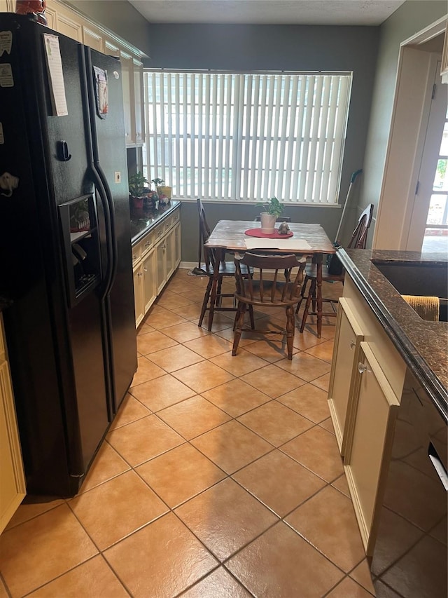 2002 Savanna Ct N, League City, TX 77573 - kitchen with black fridge, light tile patterned floors, and dark stone countertops