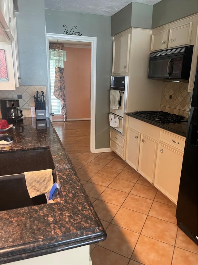 2002 Savanna Ct N, League City, TX 77573 - kitchen featuring black appliances, a warming drawer, light tile patterned floors, decorative backsplash, and a textured ceiling