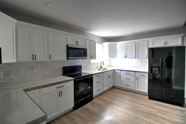 322 Montrose St, Lufkin, TX 75901 - kitchen featuring black appliances, a sink, light countertops, white cabinets, and decorative backsplash