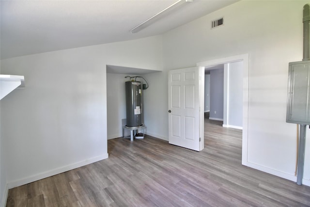 322 Montrose St, Lufkin, TX 75901 - spare room with water heater, wood finished floors, baseboards, and high vaulted ceiling