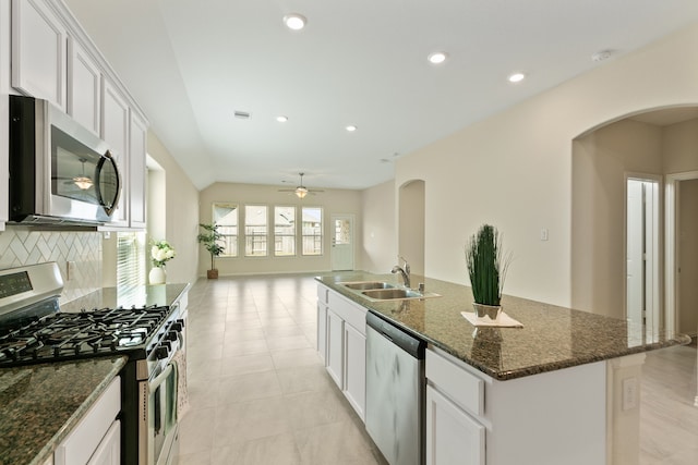 23106 Tindarey Falls Ln, Katy, TX 77493 - kitchen with stainless steel appliances, a sink, arched walkways, tasteful backsplash, and a kitchen island with sink
