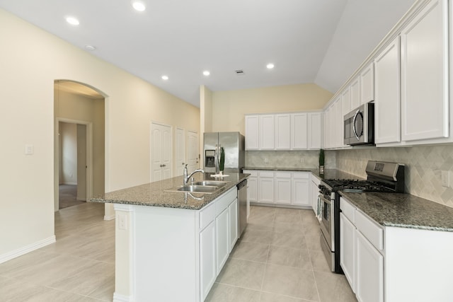 23106 Tindarey Falls Ln, Katy, TX 77493 - kitchen featuring appliances with stainless steel finishes, a sink, decorative backsplash, white cabinetry, and dark stone counters