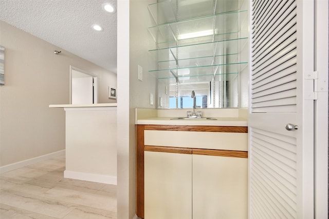 7700 Seawall Blvd Unit 512, Galveston, TX 77551 - indoor wet bar featuring a textured ceiling, baseboards, and recessed lighting