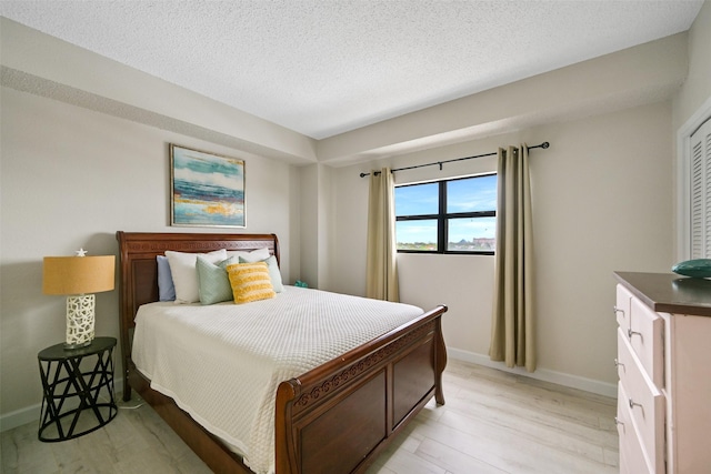 7700 Seawall Blvd Unit 512, Galveston, TX 77551 - bedroom featuring light wood finished floors and a textured ceiling