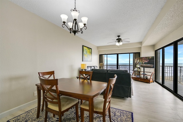 7700 Seawall Blvd Unit 512, Galveston, TX 77551 - dining room featuring a textured ceiling, plenty of natural light, ceiling fan, a chandelier, and light wood finished floors