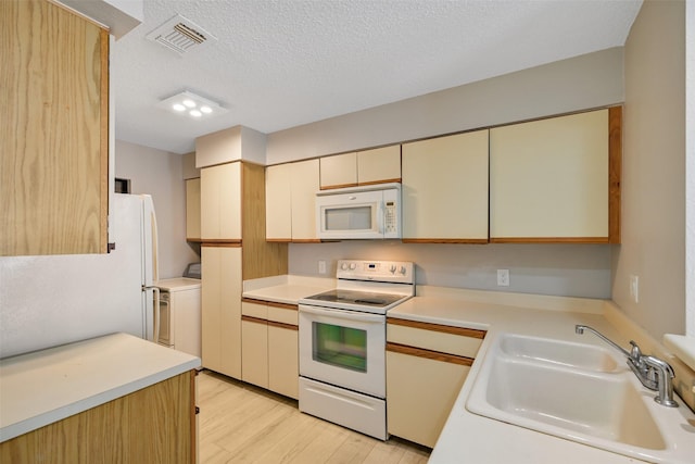 7700 Seawall Blvd Unit 512, Galveston, TX 77551 - kitchen with white appliances, light wood-style flooring, a textured ceiling, light countertops, and cream cabinetry