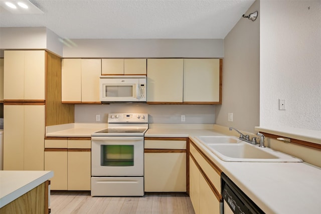 7700 Seawall Blvd Unit 512, Galveston, TX 77551 - kitchen featuring white appliances, cream cabinets, light wood-style floors, light countertops, and a textured ceiling
