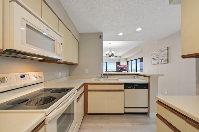 7700 Seawall Blvd Unit 512, Galveston, TX 77551 - kitchen featuring white appliances, a chandelier, a peninsula, light countertops, and a textured ceiling
