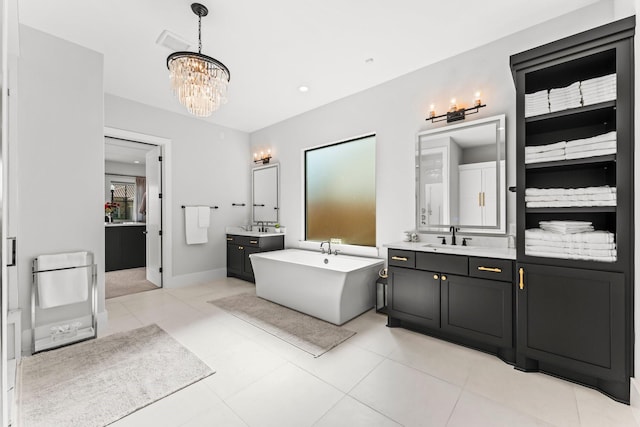 10411 E Rio Grande River Dr, Cypress, TX 77433 - bathroom with a freestanding bath, two vanities, a chandelier, tile patterned flooring, and baseboards