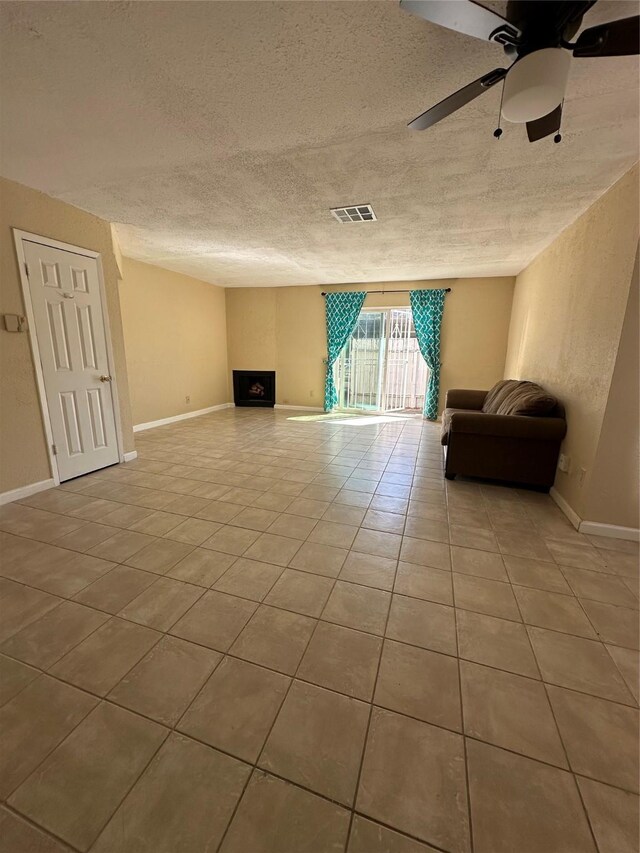8405 Wilcrest Dr Unit 2010, Houston, TX 77072 - unfurnished living room with tile patterned flooring, a textured ceiling, baseboards, and a ceiling fan