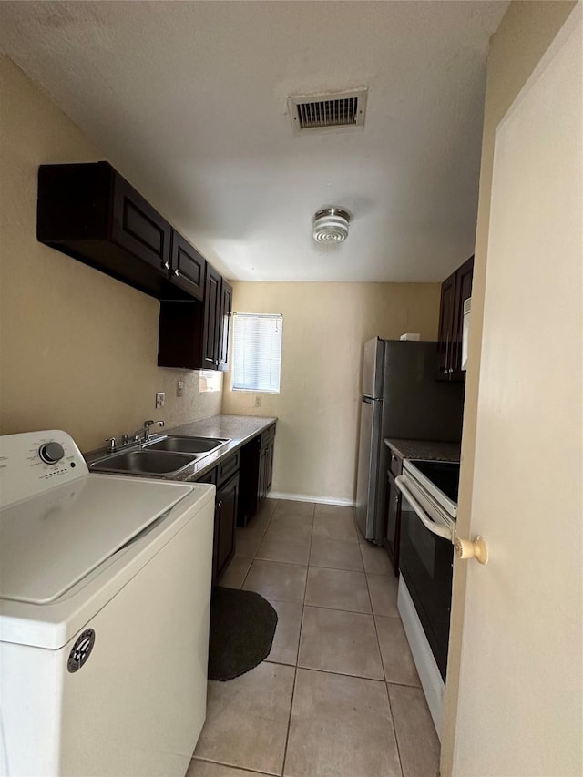 8405 Wilcrest Dr Unit 2010, Houston, TX 77072 - laundry area with washer / dryer, light tile patterned floors, and baseboards