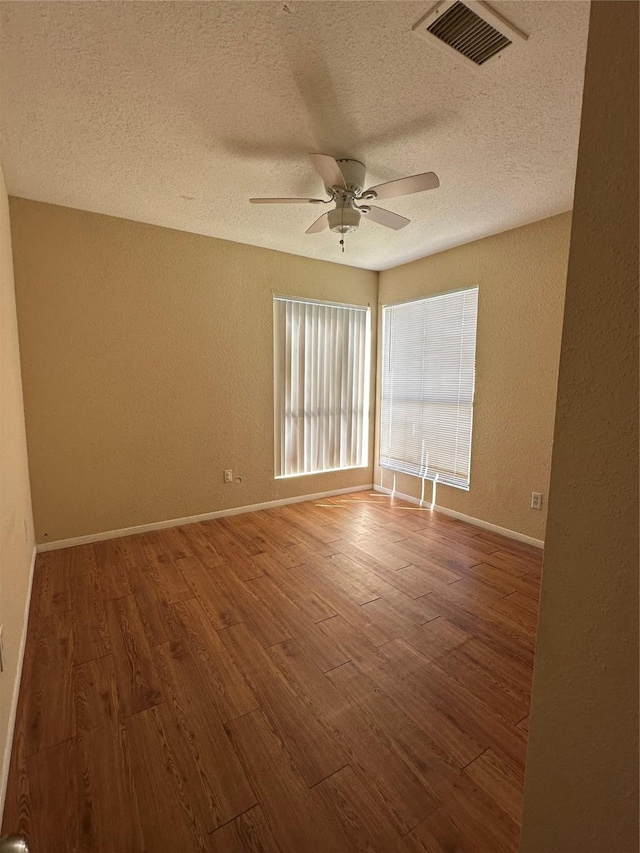 8405 Wilcrest Dr Unit 2010, Houston, TX 77072 - unfurnished room featuring a textured wall, a textured ceiling, wood finished floors, ceiling fan, and baseboards
