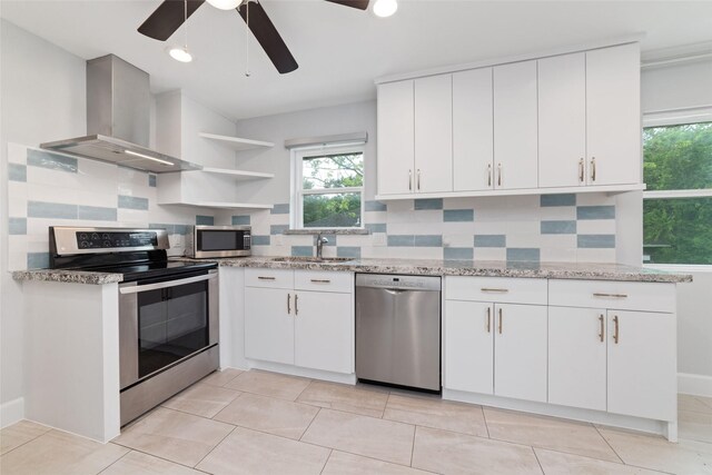 5006 Lymbar Dr, Houston, TX 77096 - kitchen featuring appliances with stainless steel finishes, exhaust hood, ceiling fan, open shelves, and backsplash
