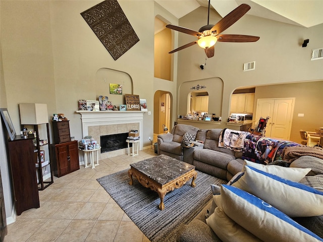 21235 Pennshore Ln, Katy, TX 77450 - living room featuring arched walkways, a ceiling fan, high vaulted ceiling, light tile patterned floors, and a fireplace