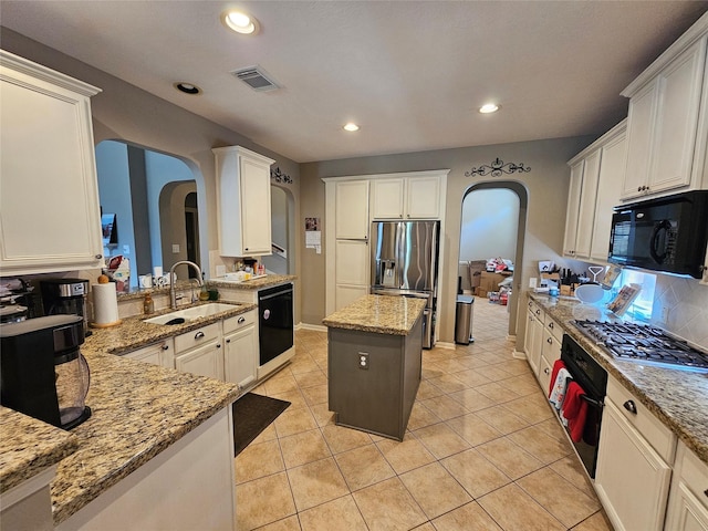 21235 Pennshore Ln, Katy, TX 77450 - kitchen with black appliances, a sink, arched walkways, light stone counters, and recessed lighting