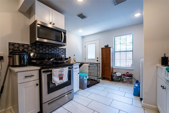 9305 Emnora Ln, Houston, TX 77080 - kitchen with appliances with stainless steel finishes, tasteful backsplash, white cabinetry, light countertops, and recessed lighting