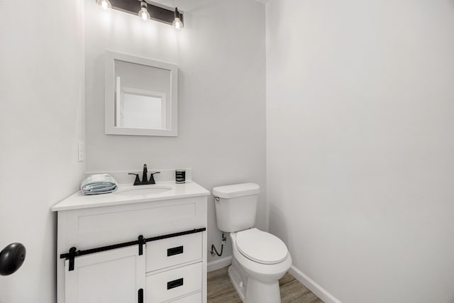 8 Donna Ct, Brookshire, TX 77423 - half bathroom with vanity, toilet, wood finished floors, and baseboards