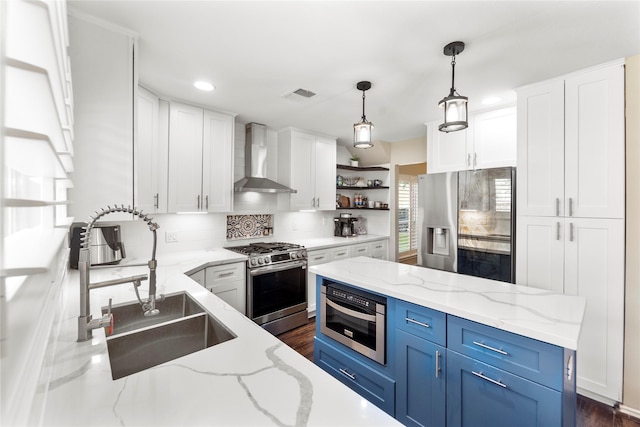 6923 Cobblestone Path, Houston, TX 77084 - kitchen with appliances with stainless steel finishes, wall chimney range hood, a sink, open shelves, and blue cabinetry