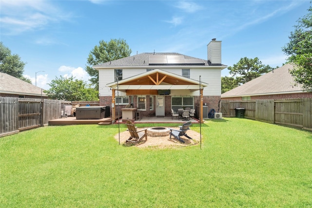6923 Cobblestone Path, Houston, TX 77084 - rear view of house featuring a hot tub, brick siding, a fire pit, a patio, and a chimney