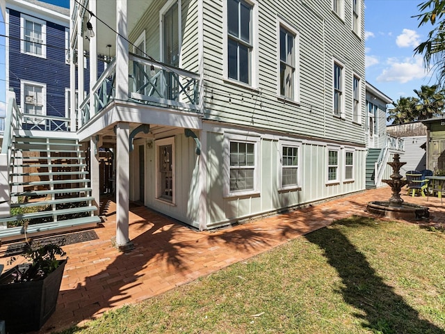 1014 20th St, Galveston, TX 77550 - view of side of home featuring stairs, a patio, and a yard