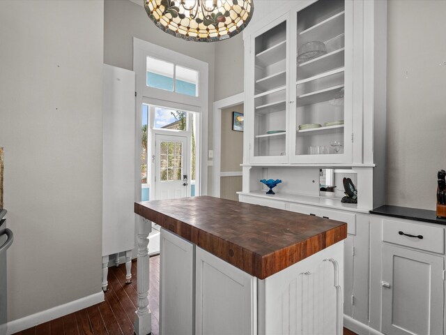 1014 20th St, Galveston, TX 77550 - kitchen with butcher block countertops, white cabinetry, a center island, dark wood-style floors, and baseboards