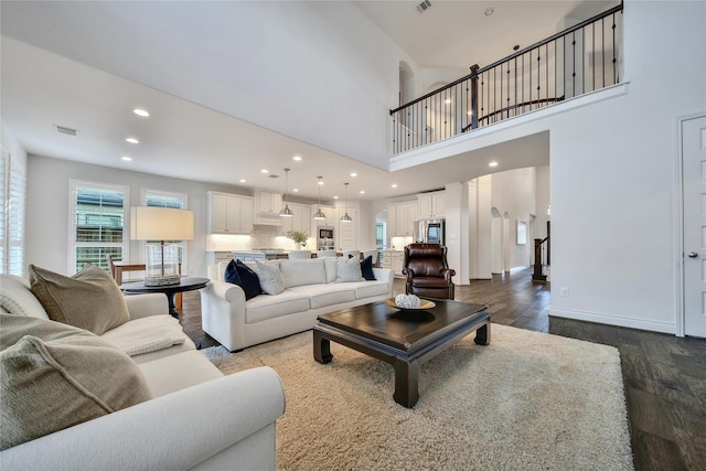 28172 Woodland Bend Way, Spring, TX 77386 - living room featuring arched walkways, dark wood-style floors, recessed lighting, and a towering ceiling