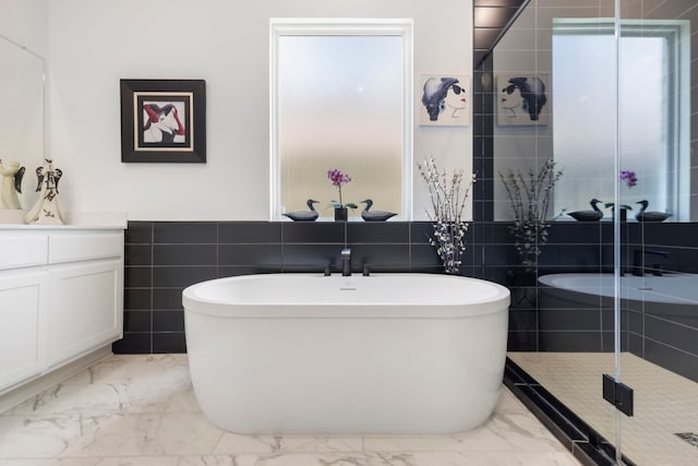 12211 Grey Plover Ct, Conroe, TX 77304 - full bathroom with a freestanding bath, marble finish floors, vanity, a stall shower, and tile walls