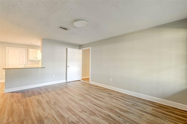 5102 Lyndhurst Dr, Houston, TX 77033 - unfurnished room featuring baseboards, light wood-type flooring, and a textured ceiling