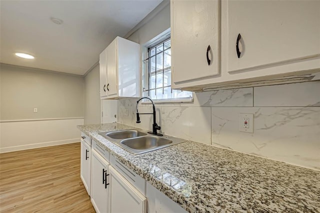 5102 Lyndhurst Dr, Houston, TX 77033 - kitchen featuring a sink, white cabinetry, and decorative backsplash