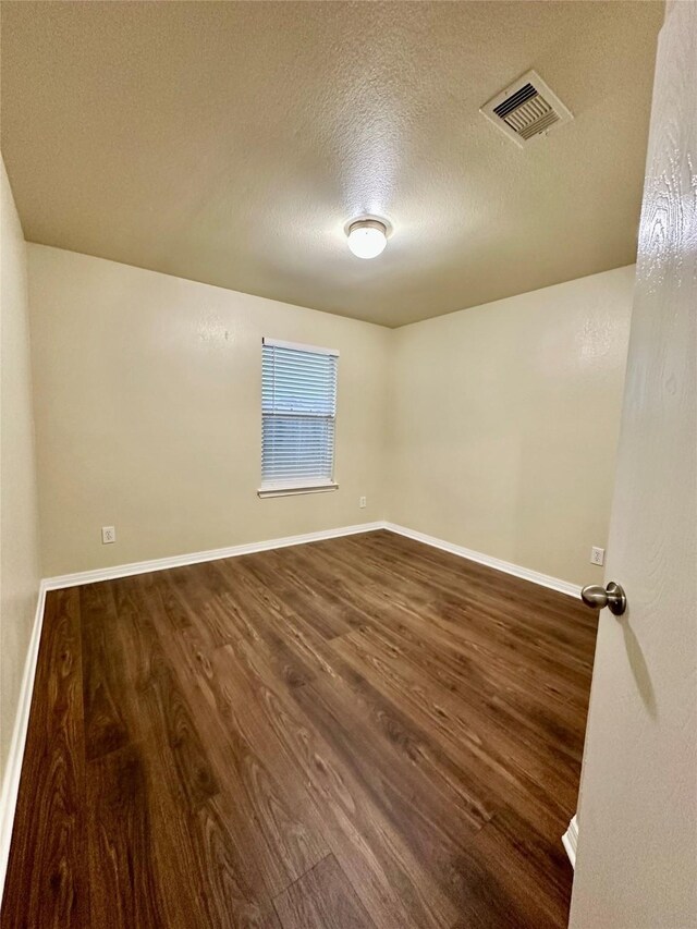 5642 Park Village Dr, Houston, TX 77048 - unfurnished room with dark wood-type flooring, a textured ceiling, and baseboards