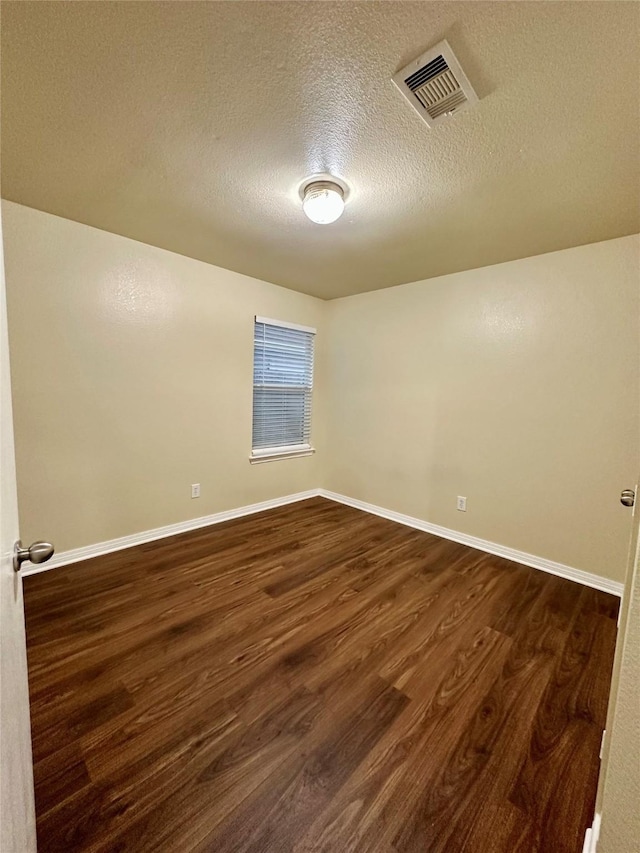 5642 Park Village Dr, Houston, TX 77048 - empty room featuring dark wood-style floors, a textured ceiling, and baseboards