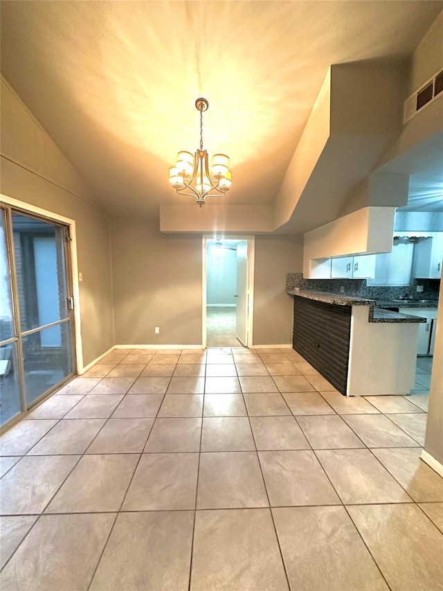3918 Dalmatian Dr, Houston, TX 77045 - kitchen with light tile patterned floors, a chandelier, decorative backsplash, decorative light fixtures, and baseboards