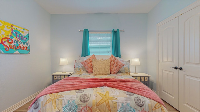 923 Tidelands Dr, Galveston, TX 77650 - bedroom featuring wood finished floors, a closet, and baseboards